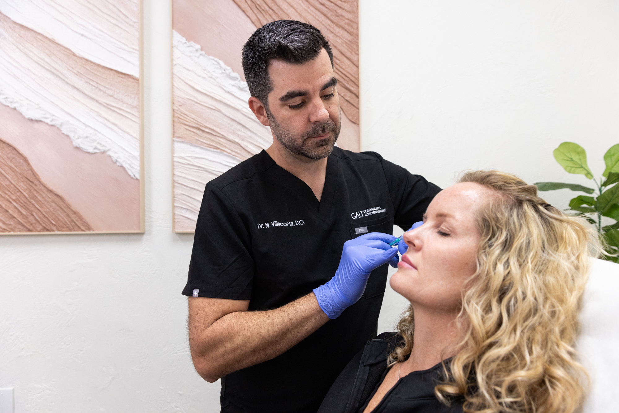 Provider carefully places collagen injections in Fort Lauderdale into patient's cheek to help her age gracefully. The patient leans back with eyes closed throughout the process.
