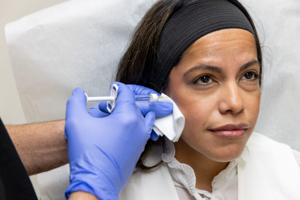 Provider injects dermal filler into patients cheek to add more definition. This is part of a thoughtful approach to facial balancing in Fort Lauderdale.