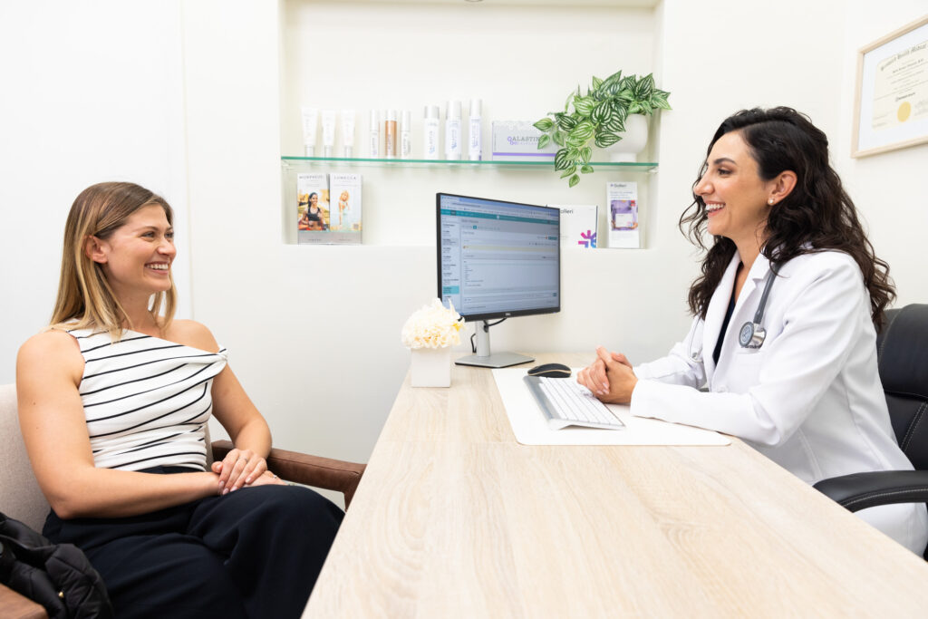 A female patient smiles during a consultation with a boutique doctor near you