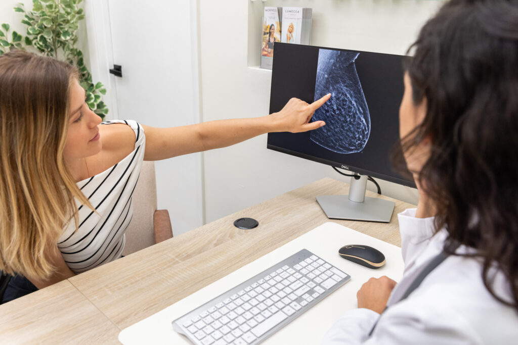 A female patient points at a computer while discussing her results from a breast cancer screening in Fort Lauderdale with a physician